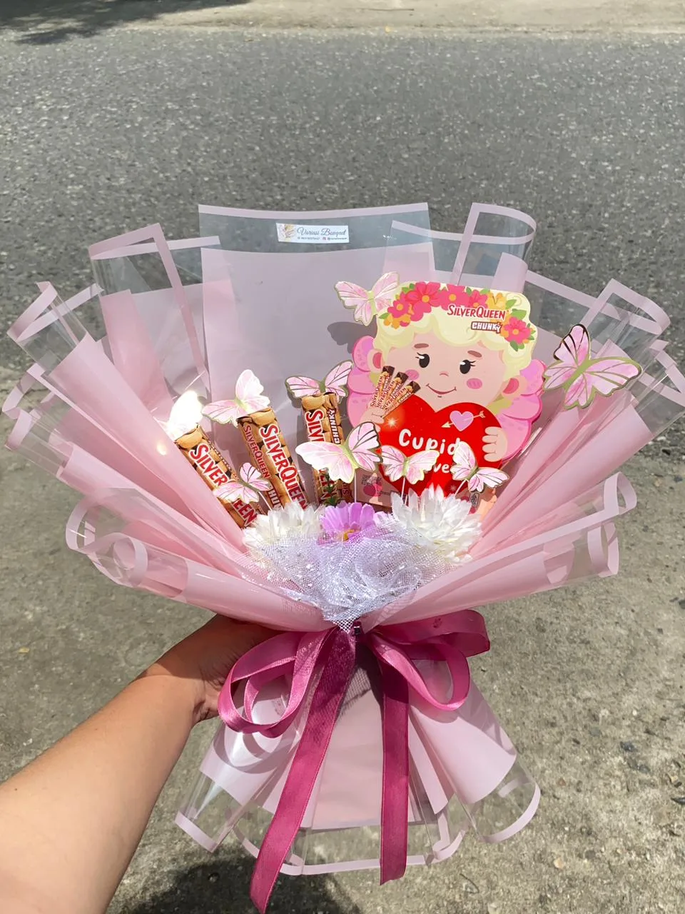 Buket cokelat dengan boneka mungil di tengah
